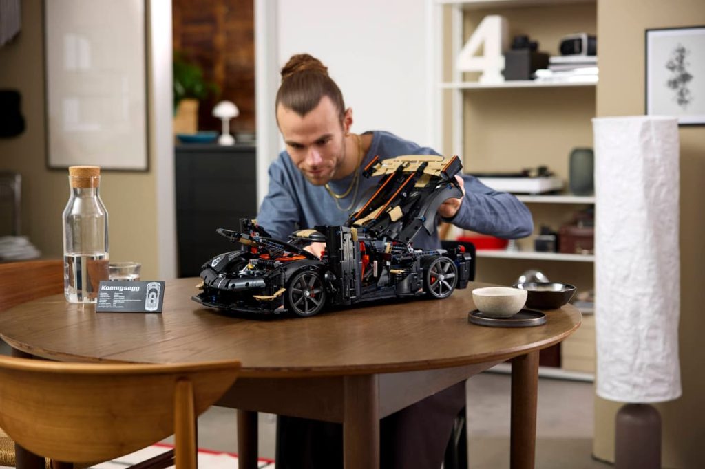 A man holding a model of a car on a table