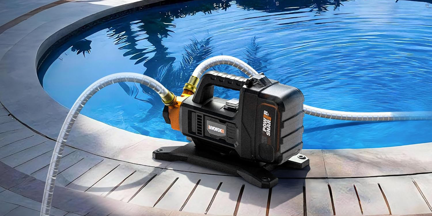 A black and orange machine with hoses on edge of pool