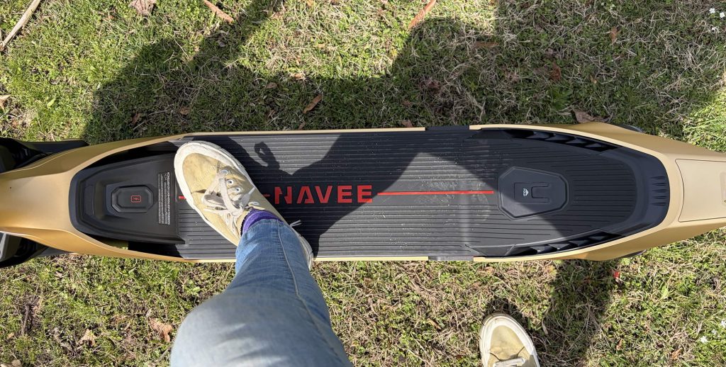 A person's feet on a black and red skateboard