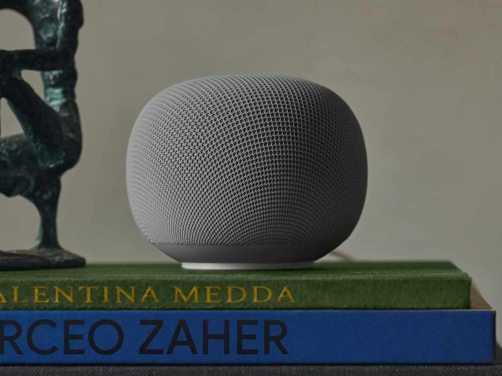 A grey speaker on top of books