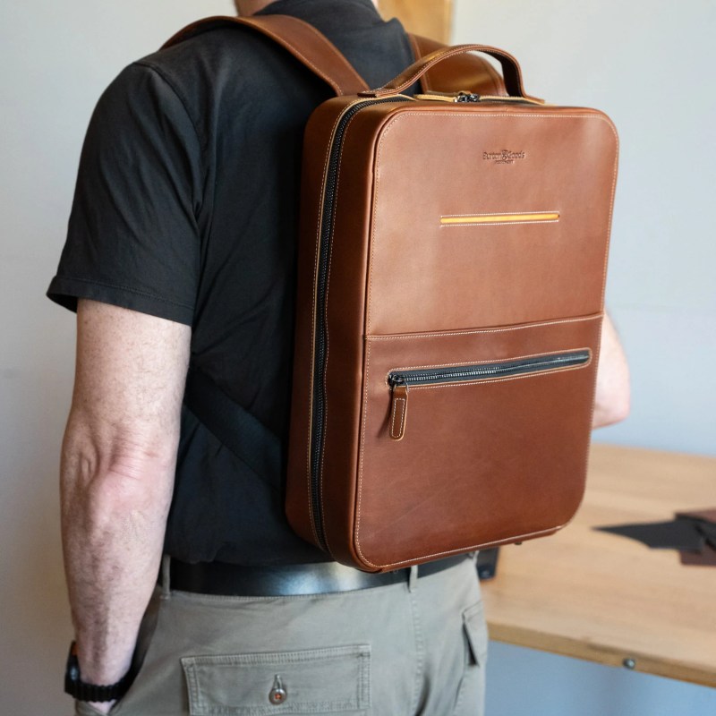 A man wearing a brown backpack
