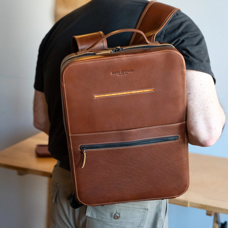 A person carrying a brown backpack