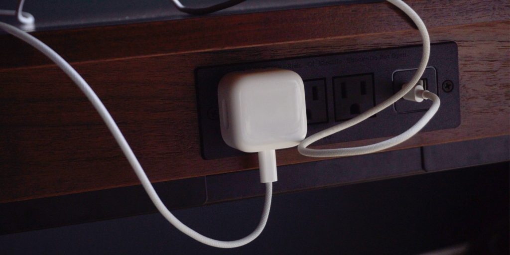 A white cord plugged into a wall outlet