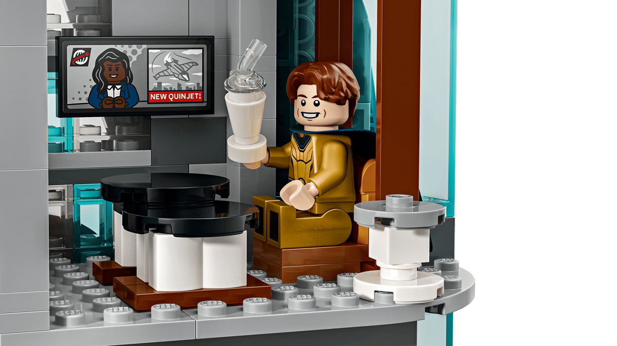 A lego figure sitting in a chair holding a blender
