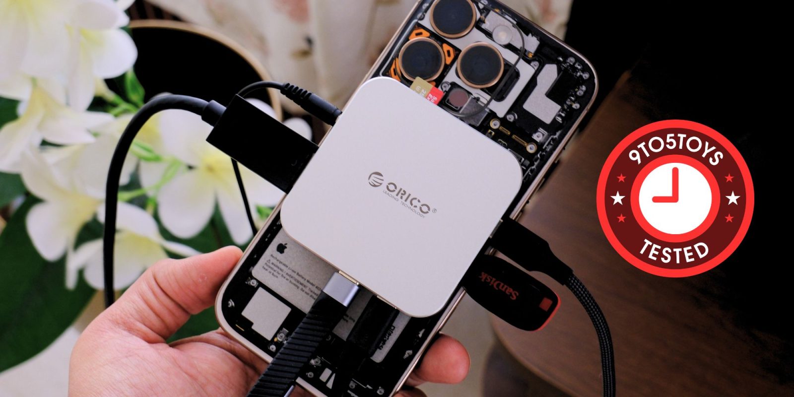 A hand holding a device with wires