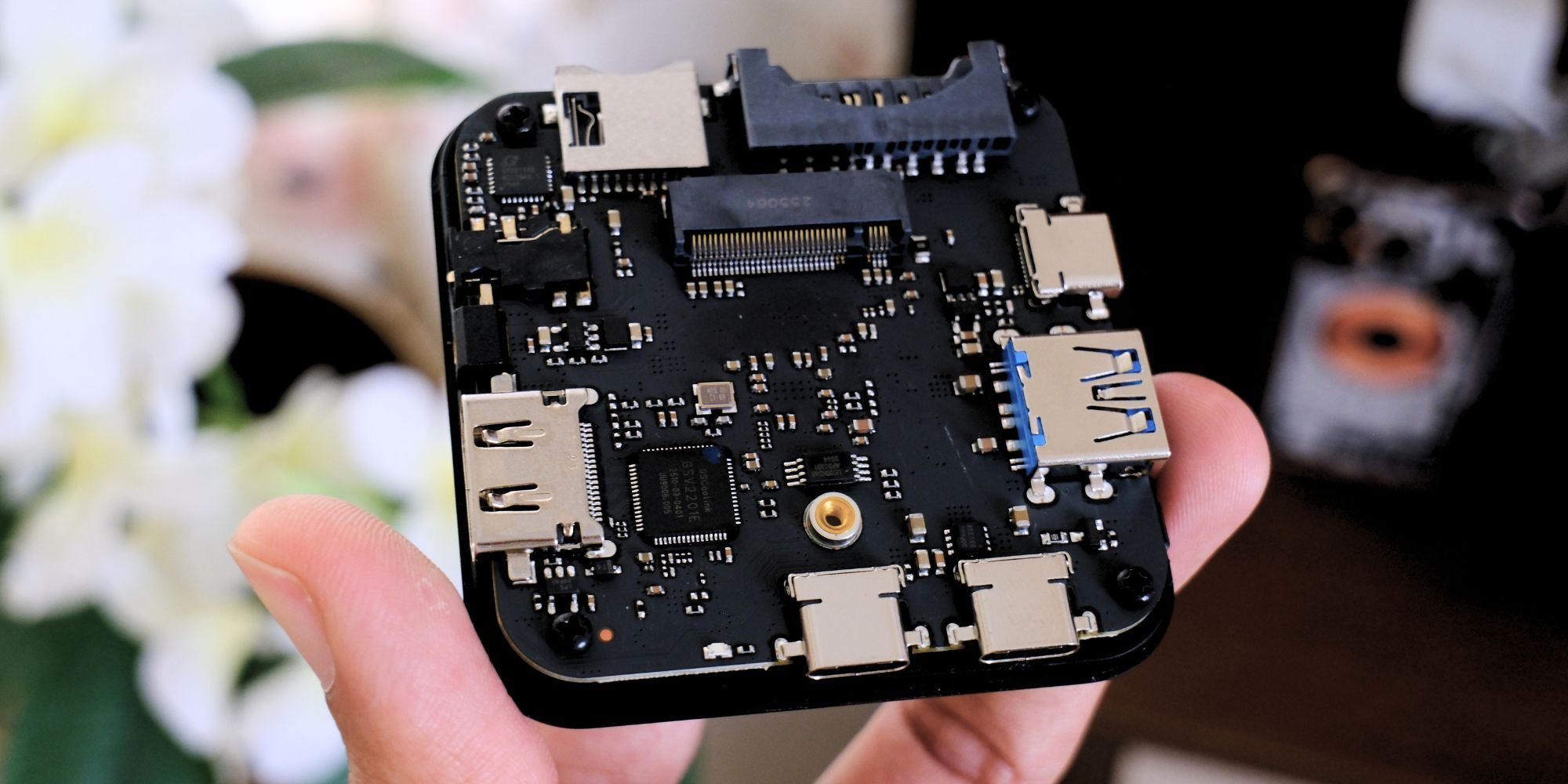 A hand holding a black electronic device