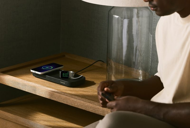 A man sitting on a table with a phone and a charger