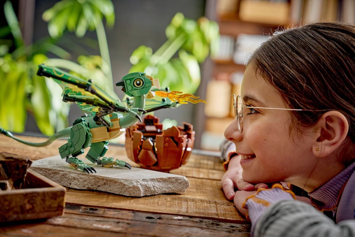 A girl looking at a toy dragon