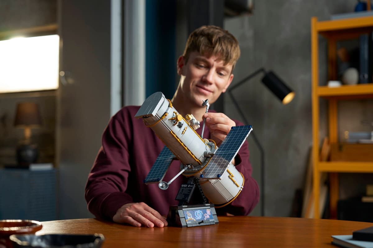 A man fixing a model of a satellite