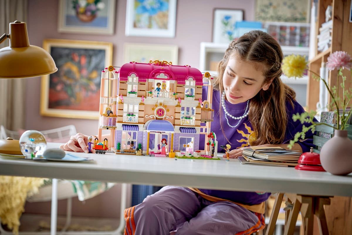 A girl sitting at a table with a toy building