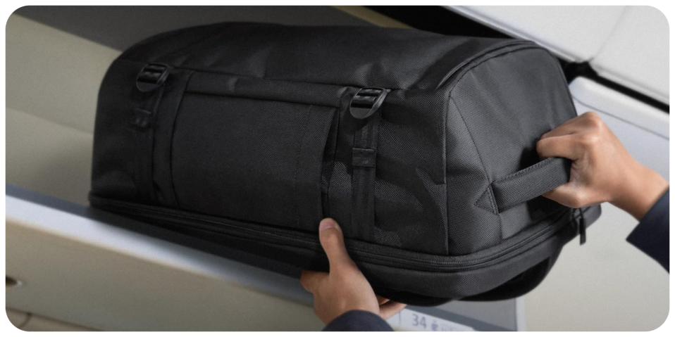 A person holding a black bag