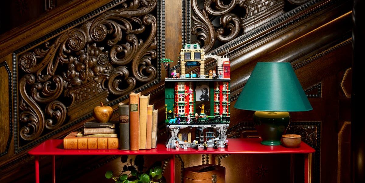 A shelf with a lamp and a toy house on it