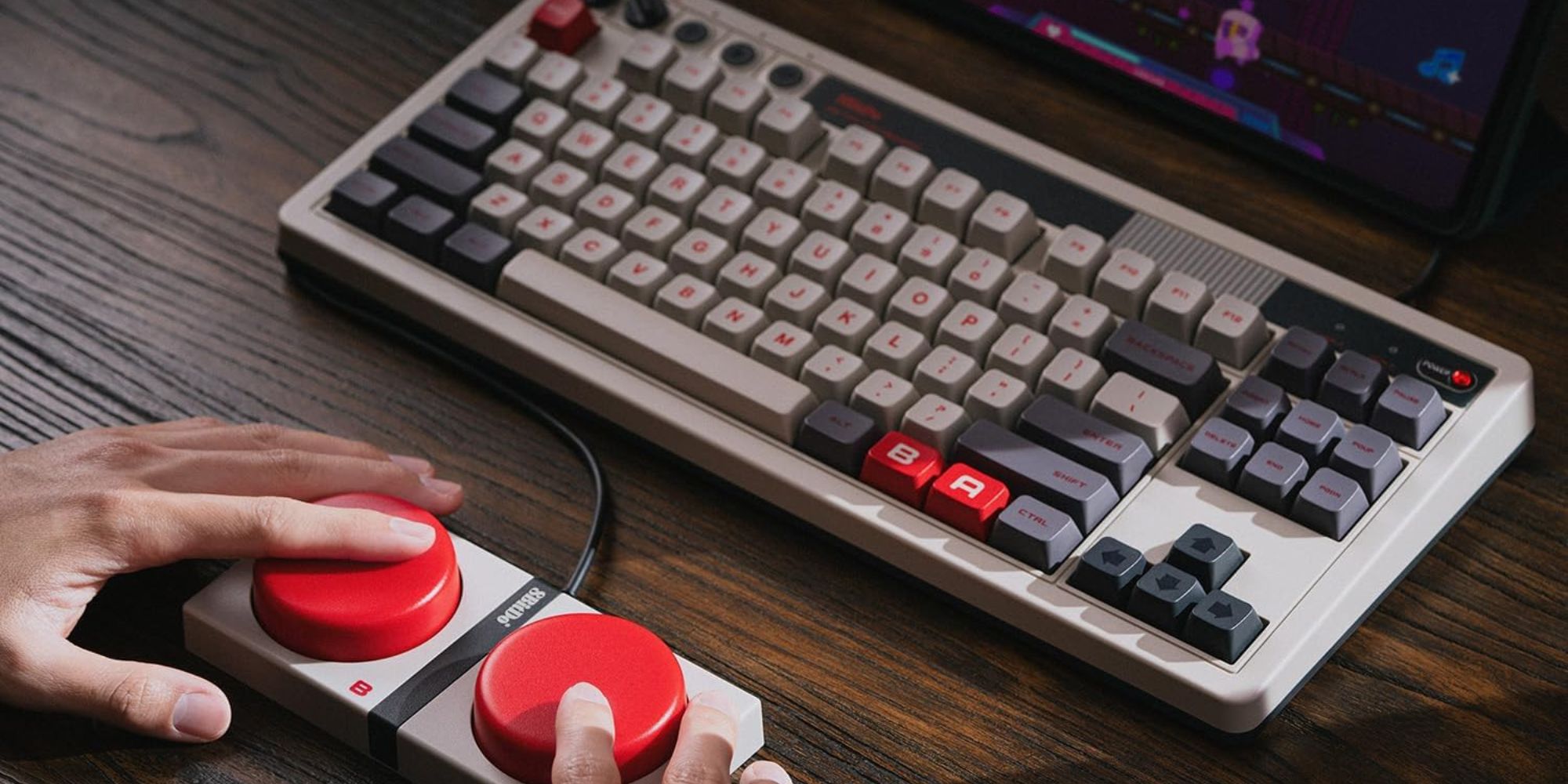 A hand holding a red and grey keyboard