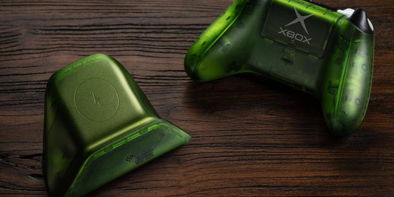 A green gaming controllers on a wood surface
