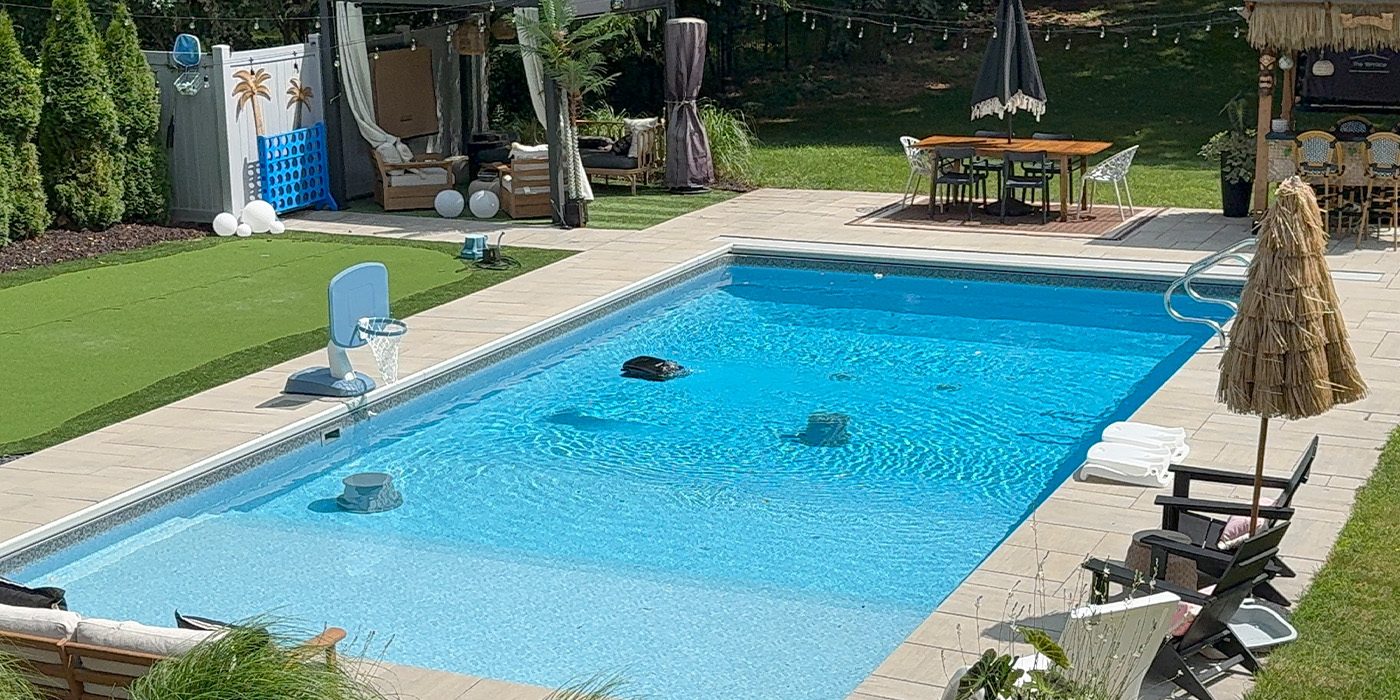 A swimming pool with a lawn and chairs