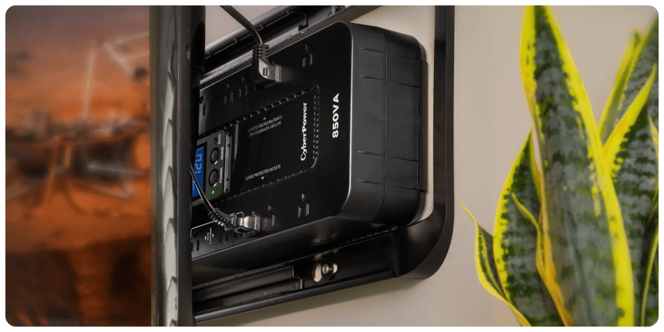 A black electronic device with a green plant in the background