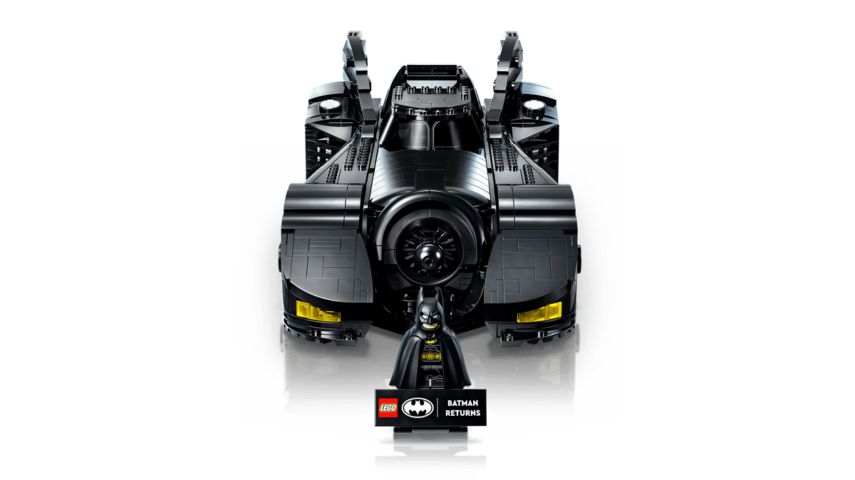 A lego batman figure next to a black batmobile