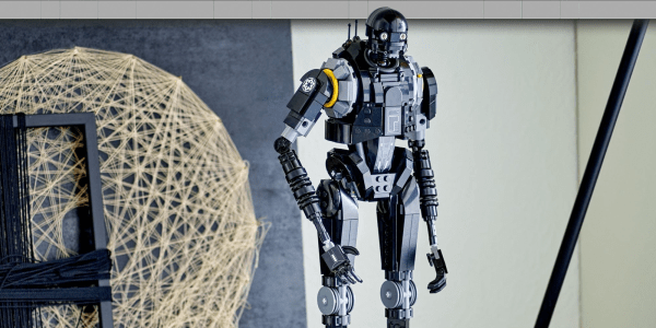 A toy robot standing in front of a white and yellow globe