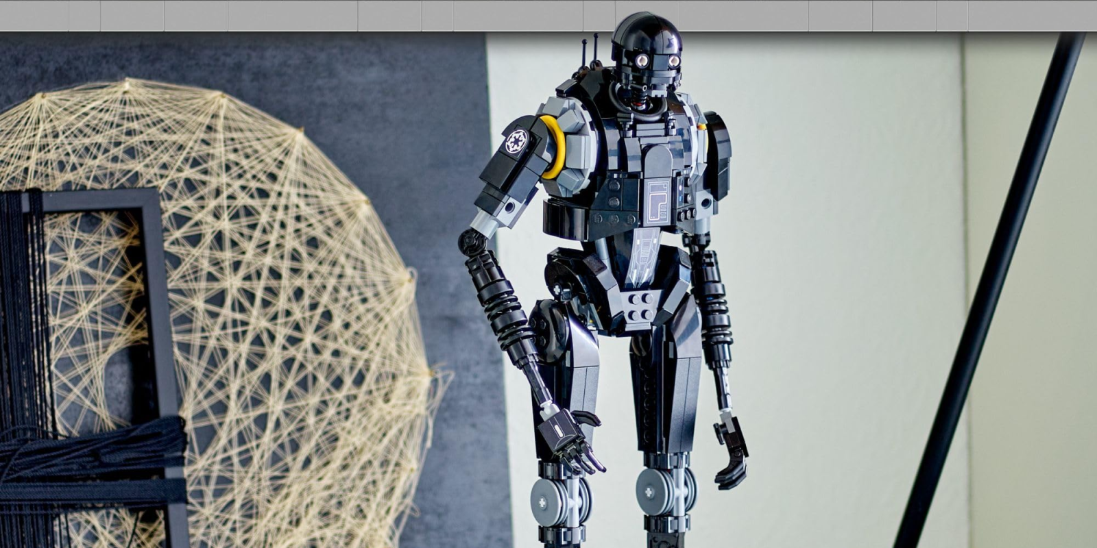 A toy robot standing in front of a white and yellow globe