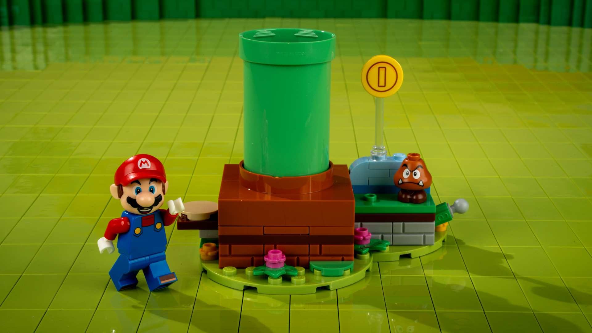A toy figurine of a man and a green cylinder