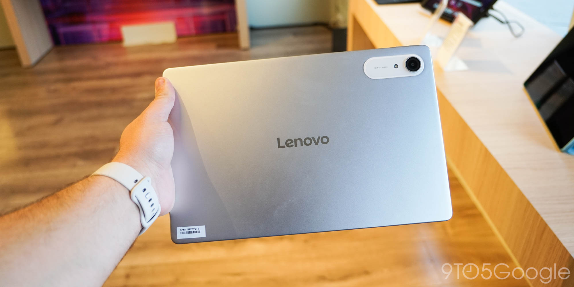 A person holding a silver tablet