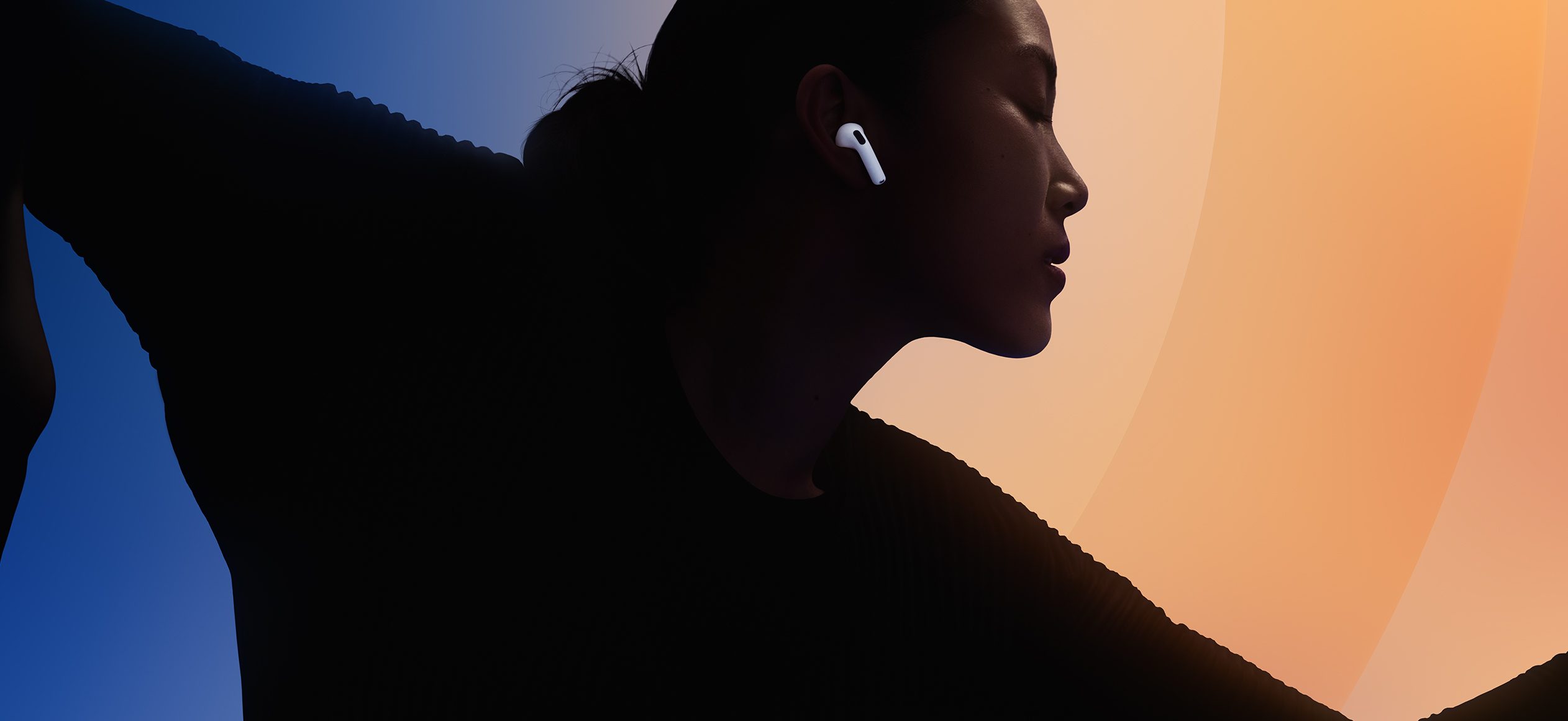 A woman with her eyes closed and earbuds in her ear