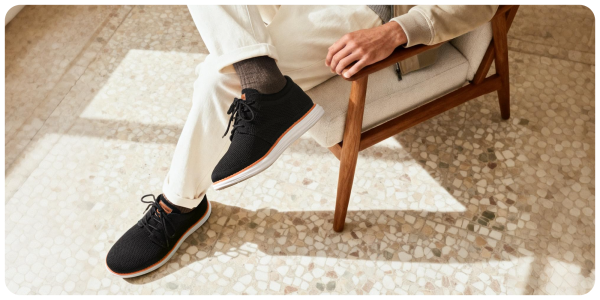 A person wearing black shoes and white pants