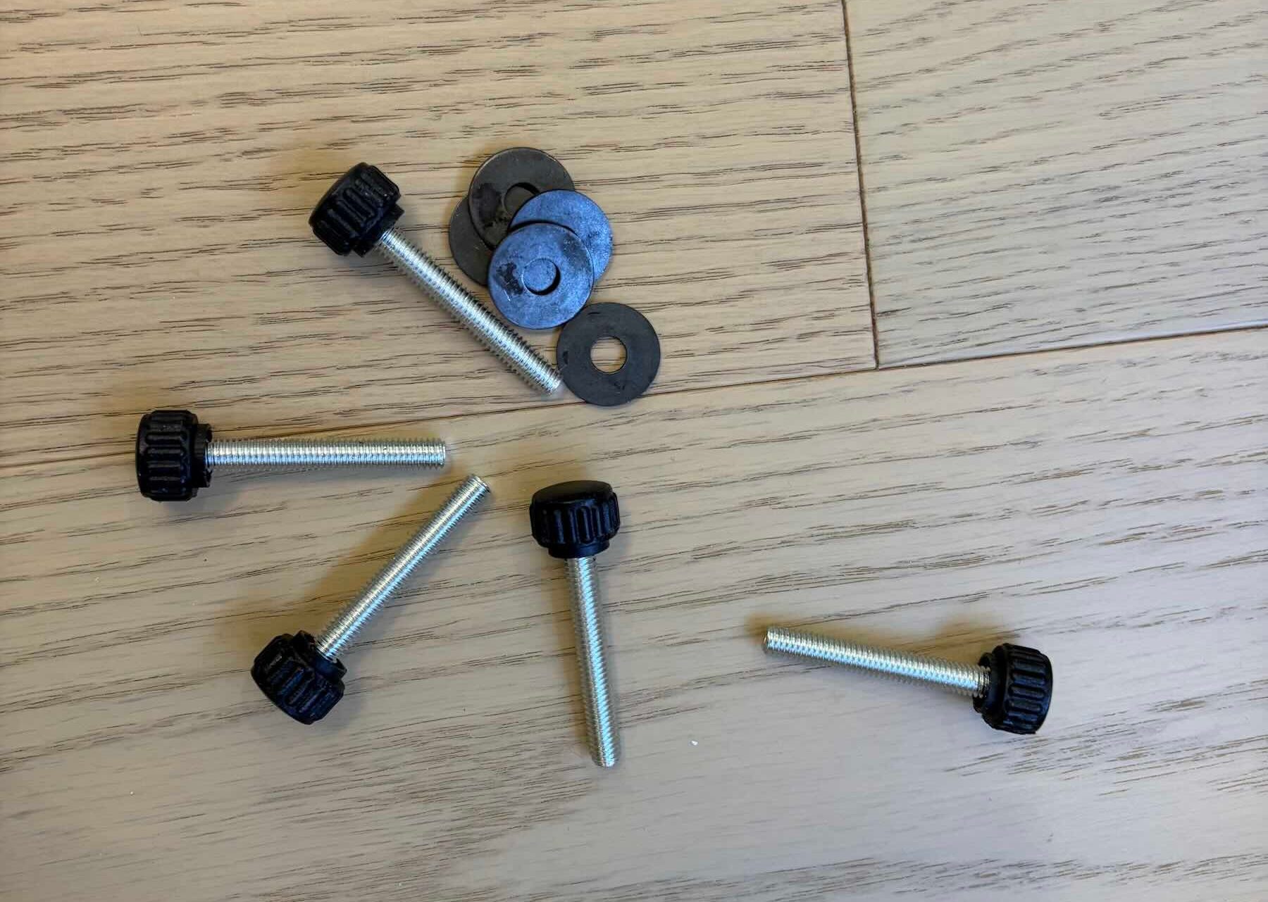 A group of screws and washers on a wood surface
