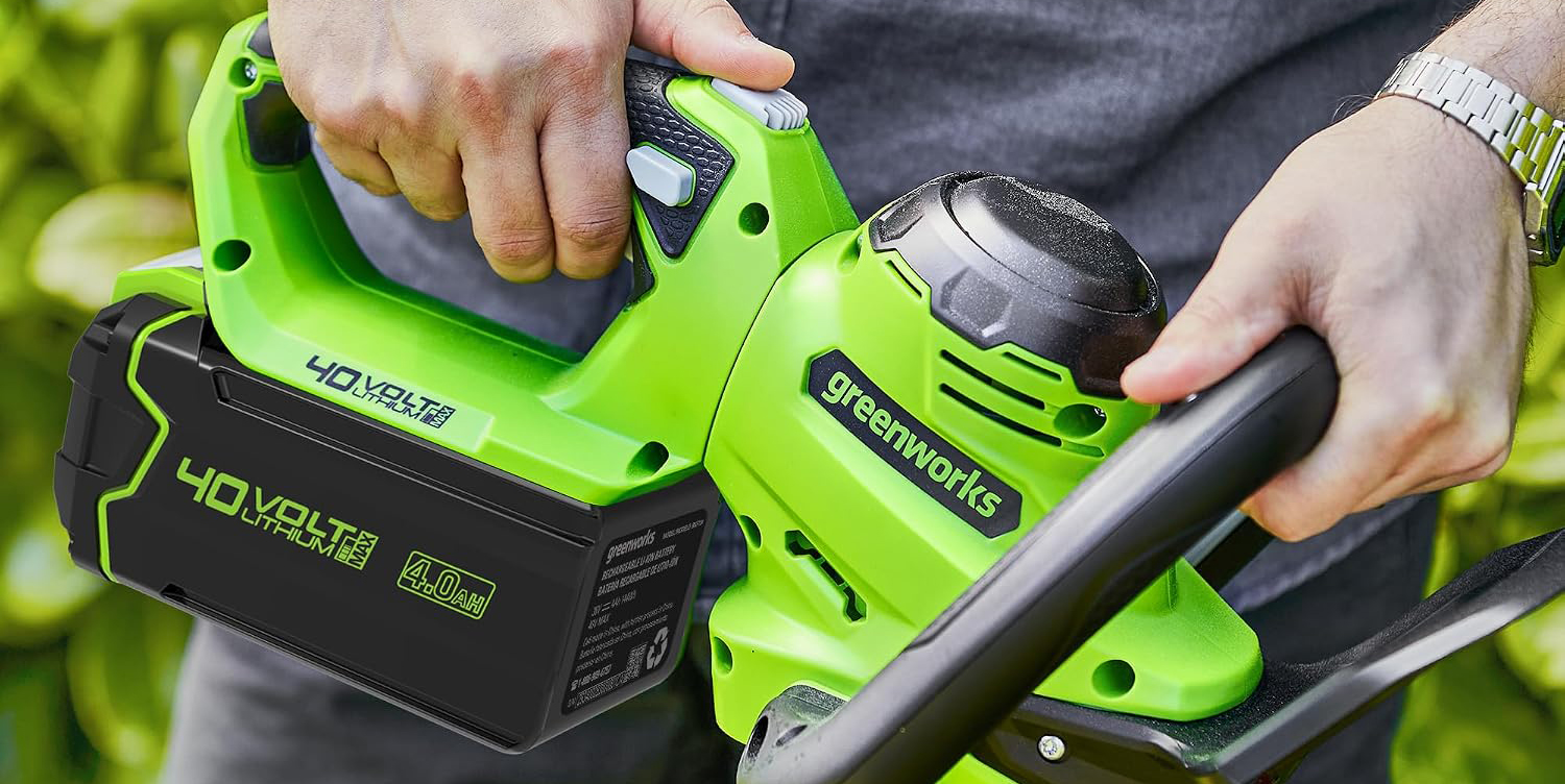 A person holding a green and black power tool