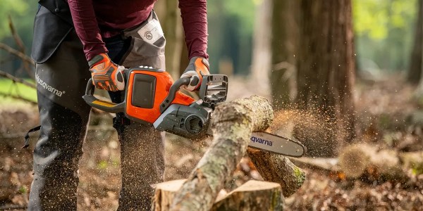 A person using a chainsaw to cut a tree