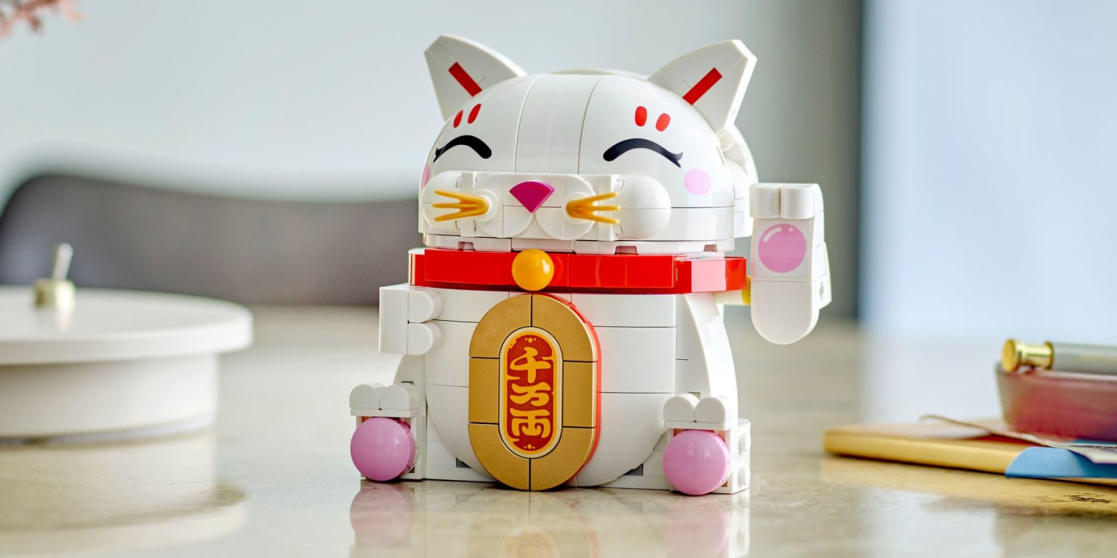 A white cat toy with red and gold accents