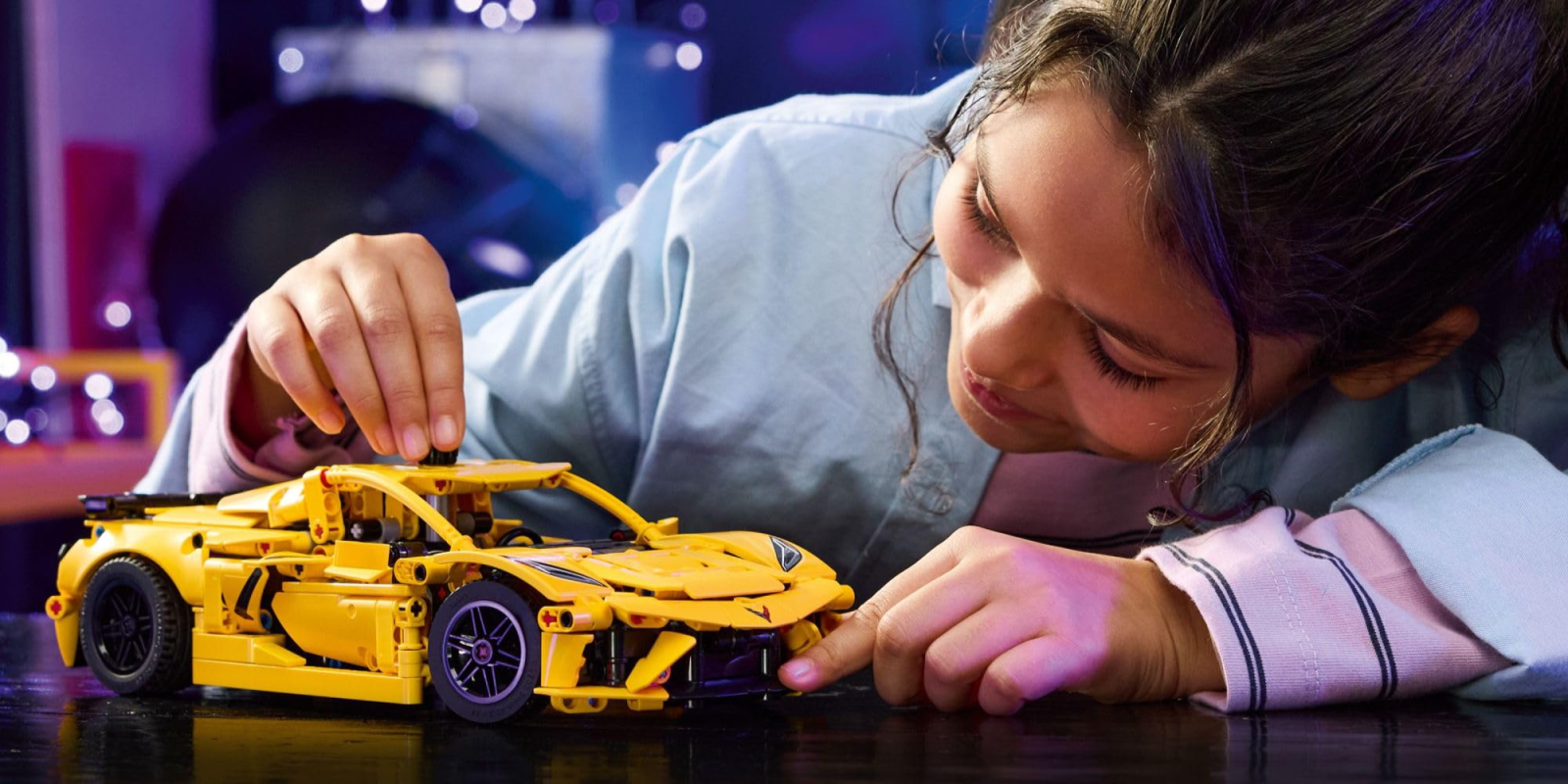 A girl playing with a toy car