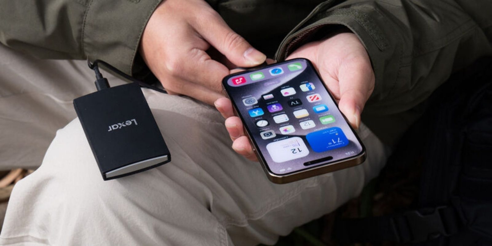 Image showing a person using Lexar's ARMOR 700 portable SSD with their iPhone.