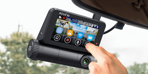 A hand touching a car camera