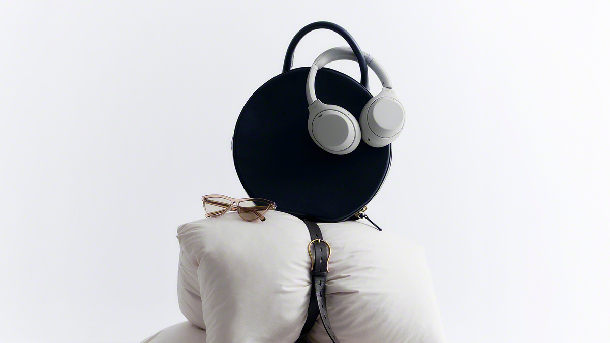 A bag with headphones on top of a pillow