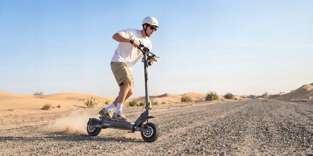 A man riding a scooter on a dirt road