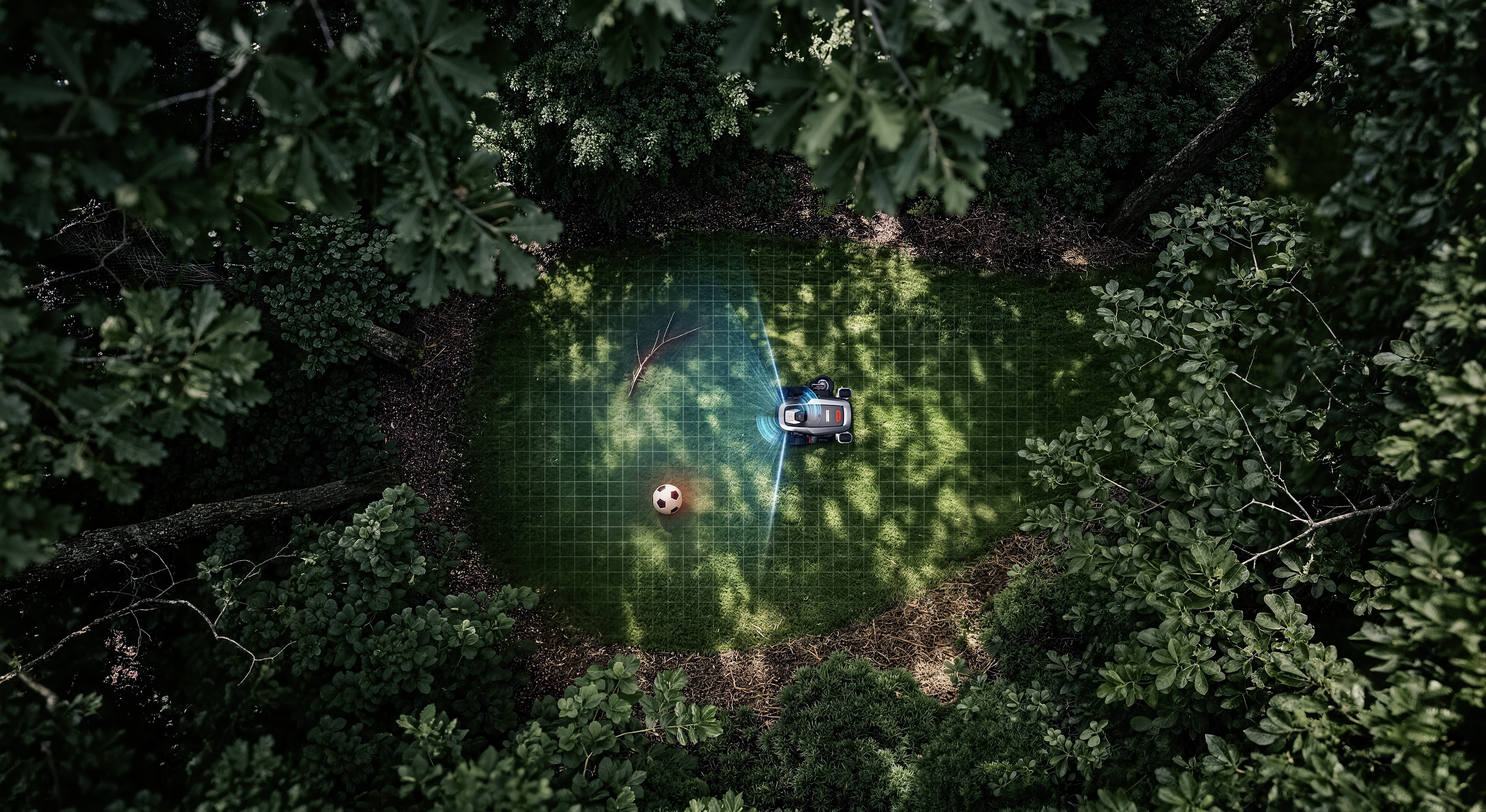 A drone view of a lawn with a football ball and a machine