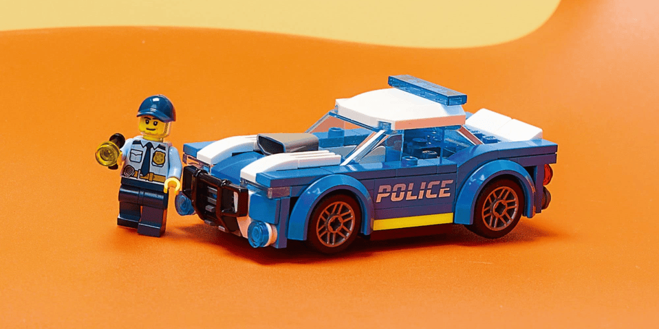 A toy police car with a lego figure