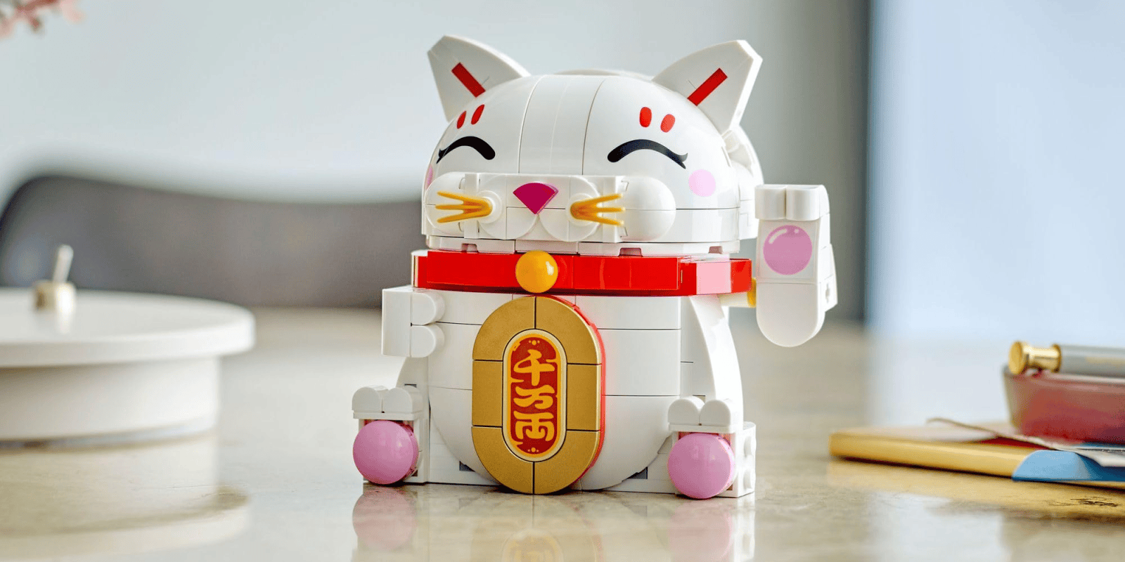 A white cat toy with red and gold accents